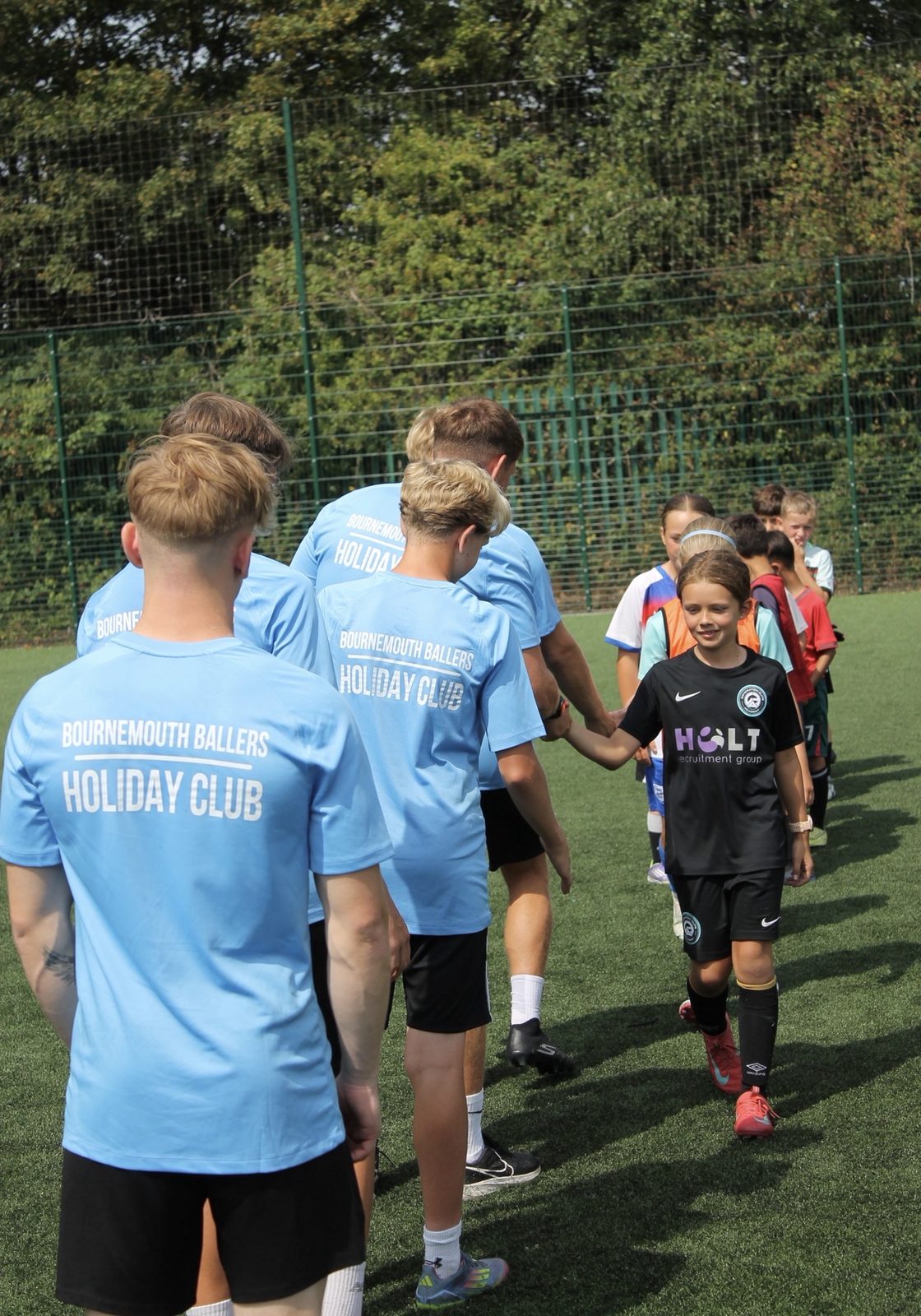 Bournemouth Ballers coaches walking out with children at the start of a summer camp session