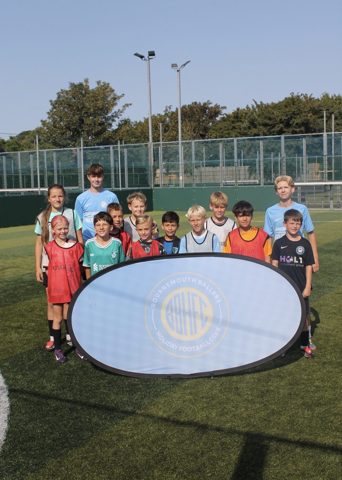 The Bournemouth Ballers holiday camp group gathered around the club banner at Pelhams Park